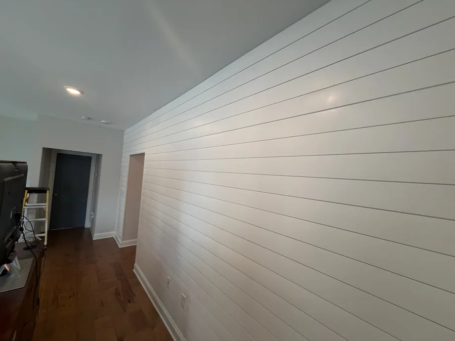 Long white shiplap accent wall in a living room